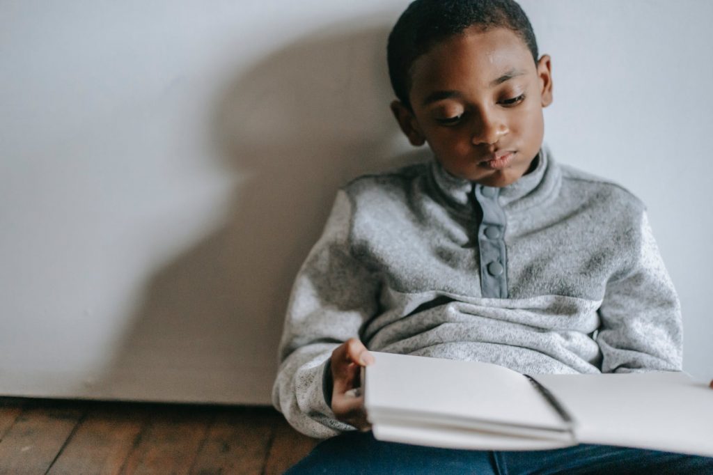 thoughtful black boy with copybook