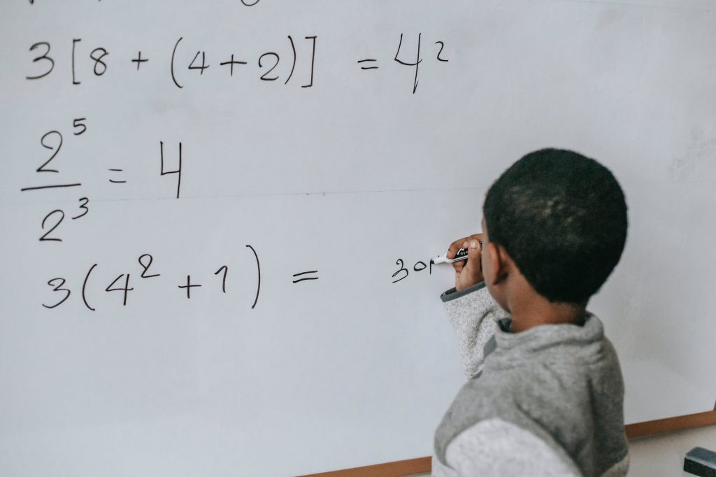 concentrated black kid doing sums