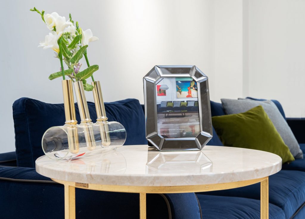 flowers and stylish frame on table