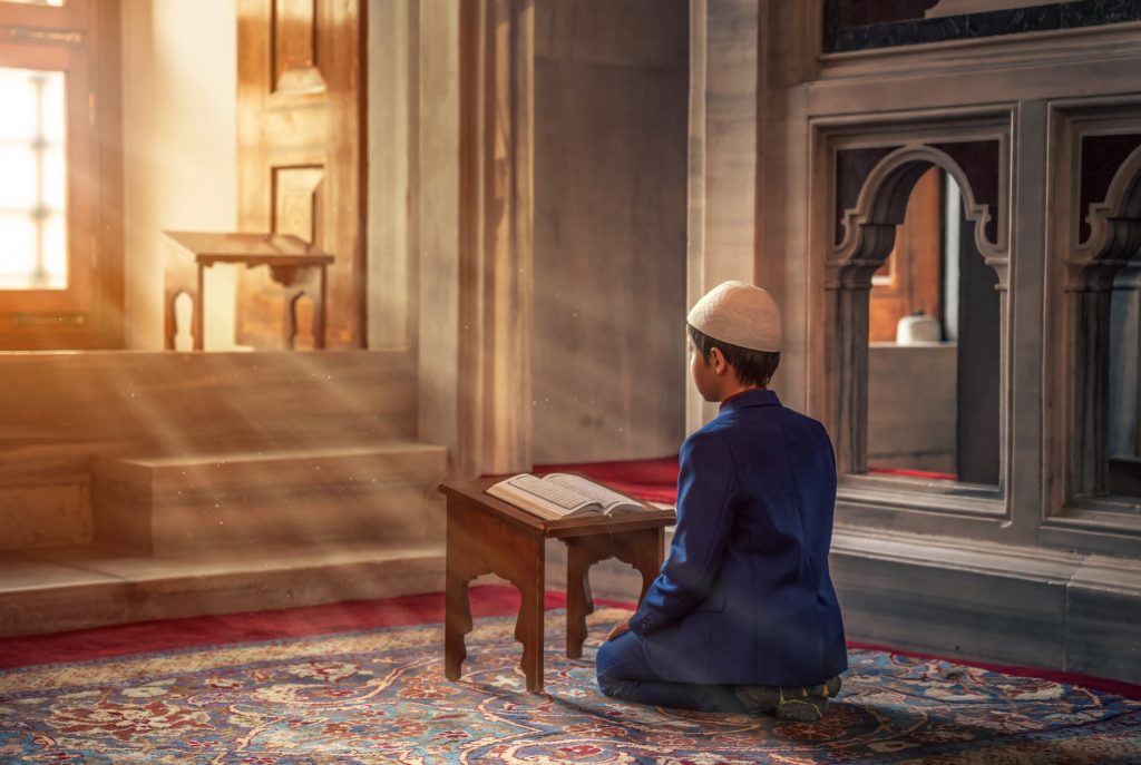photo of person kneeling in front of a book