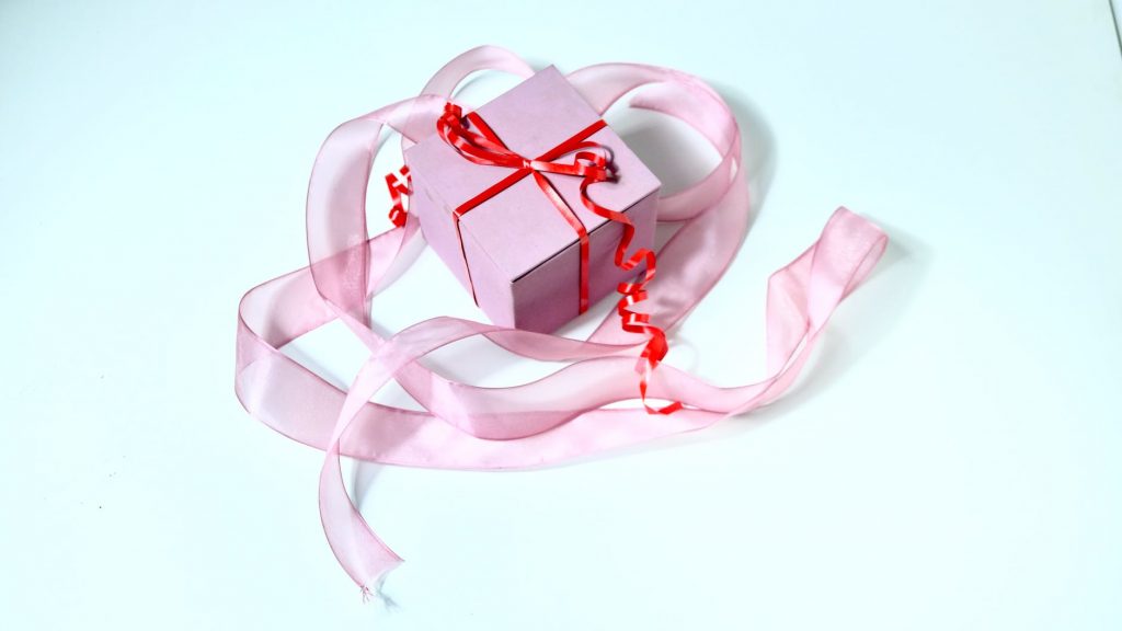 present box decorated with red band and ribbon
