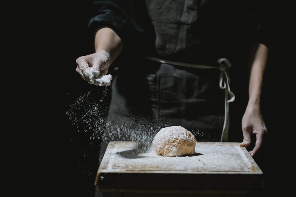 cook sprinkling flour on dough for pastry
